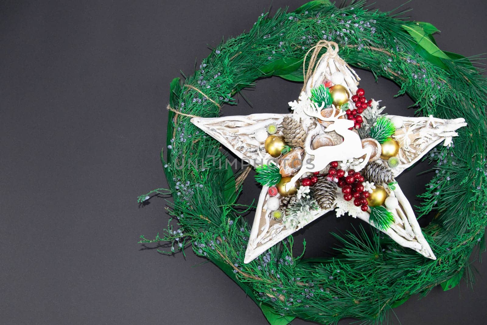 Handmade star decorated with cones and cranberries with christmas deer