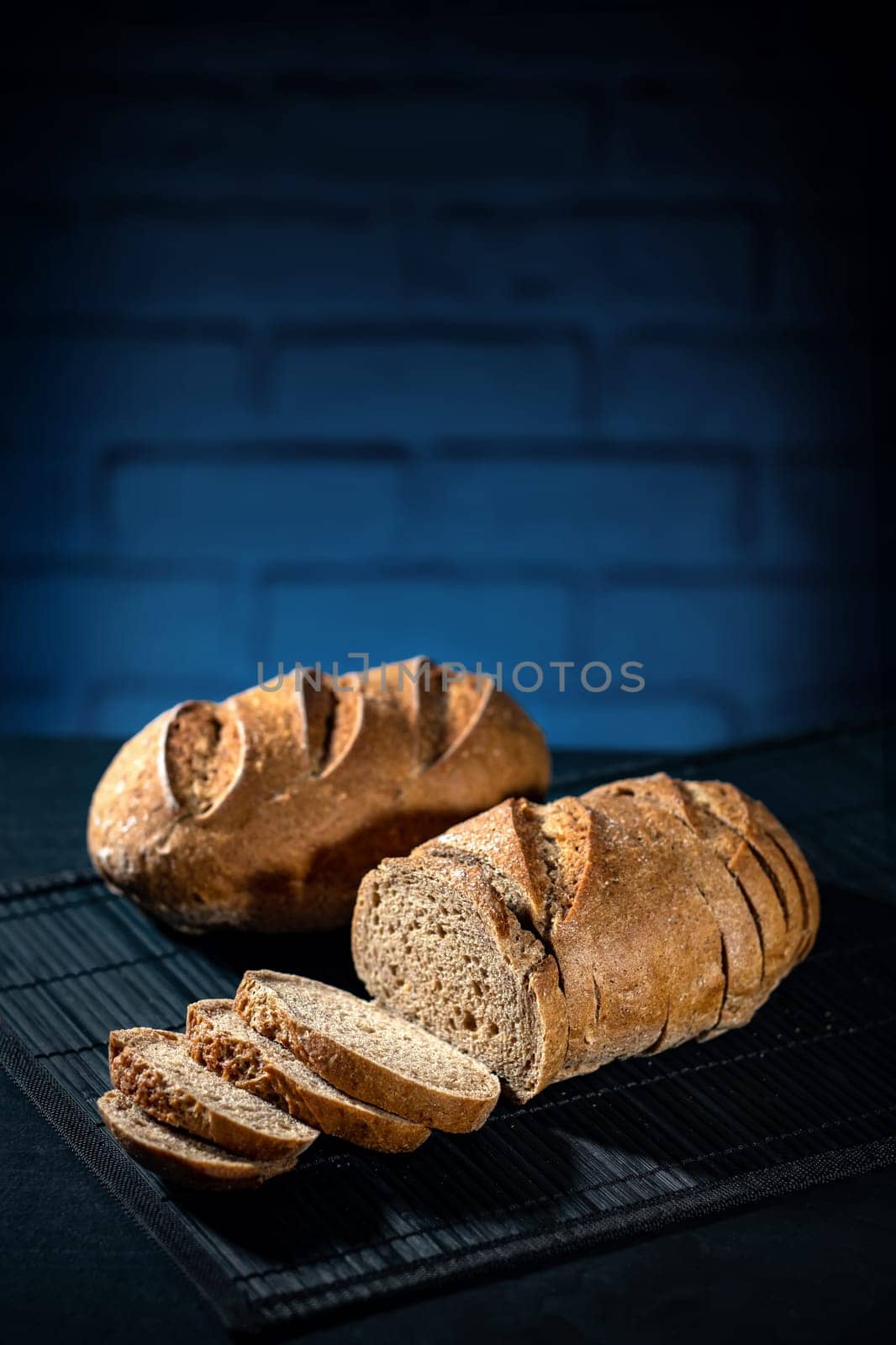 Gluten free multi dark bread on a black table and blue bricks background