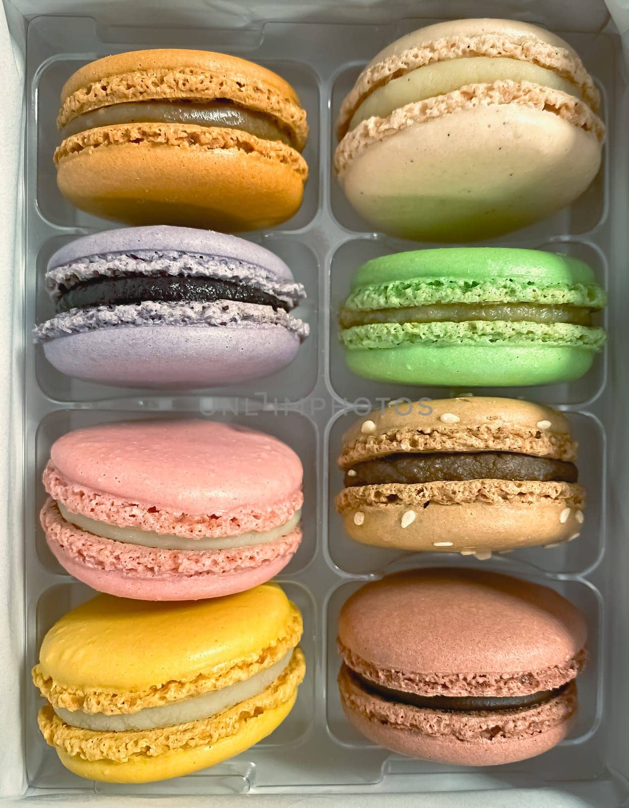 a group of colorful macarons stacked in a plastic package. Meringue-based dessert