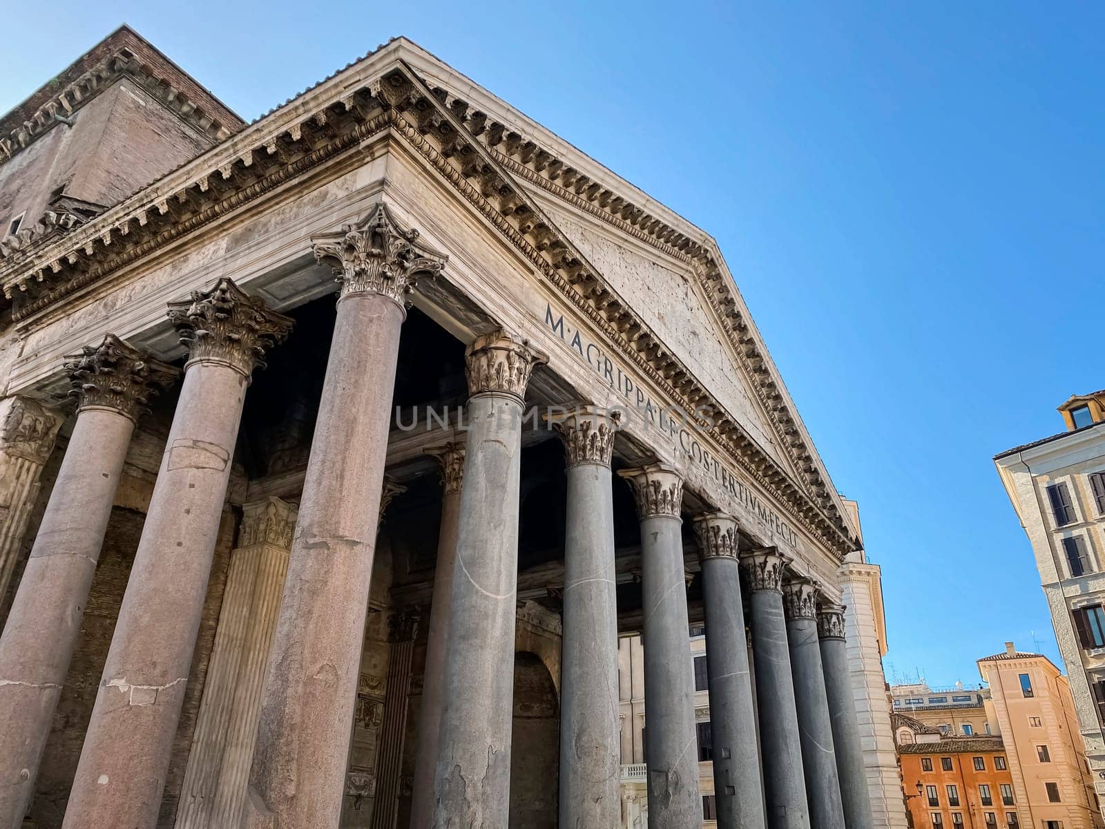 Wide angle shot of the facade with columns of the Pantheon in Rome. Travel destination and famous place. Roman Empire and architecture
