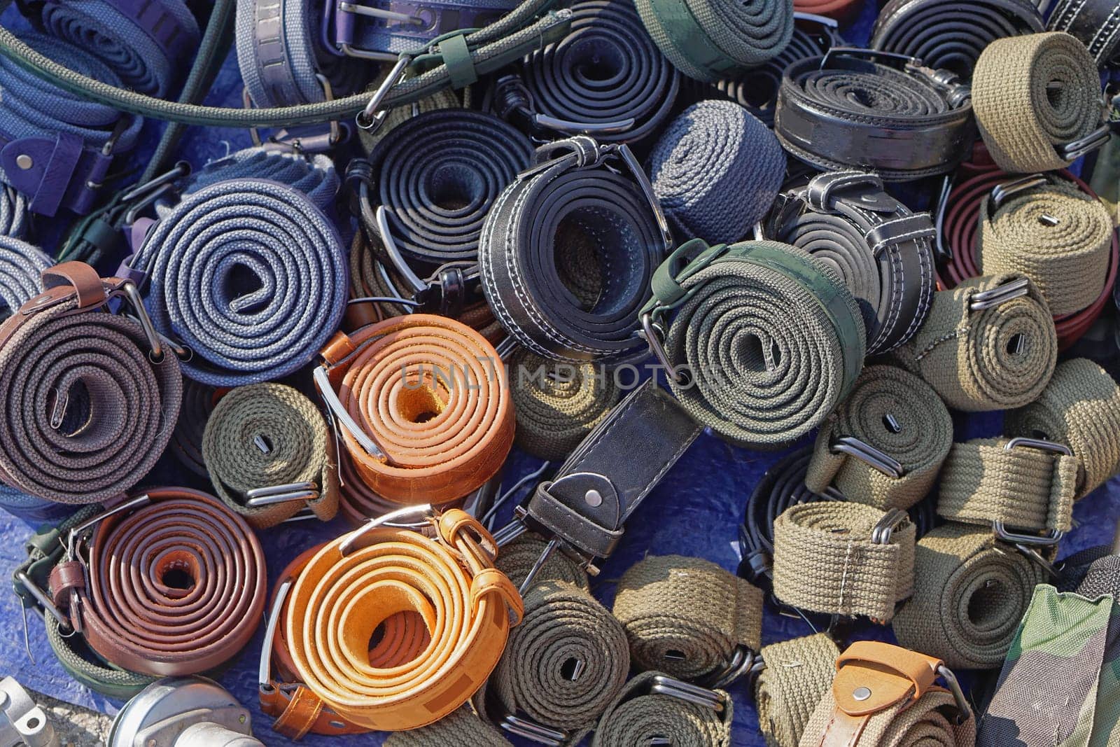 Various military style belts in coils for sale