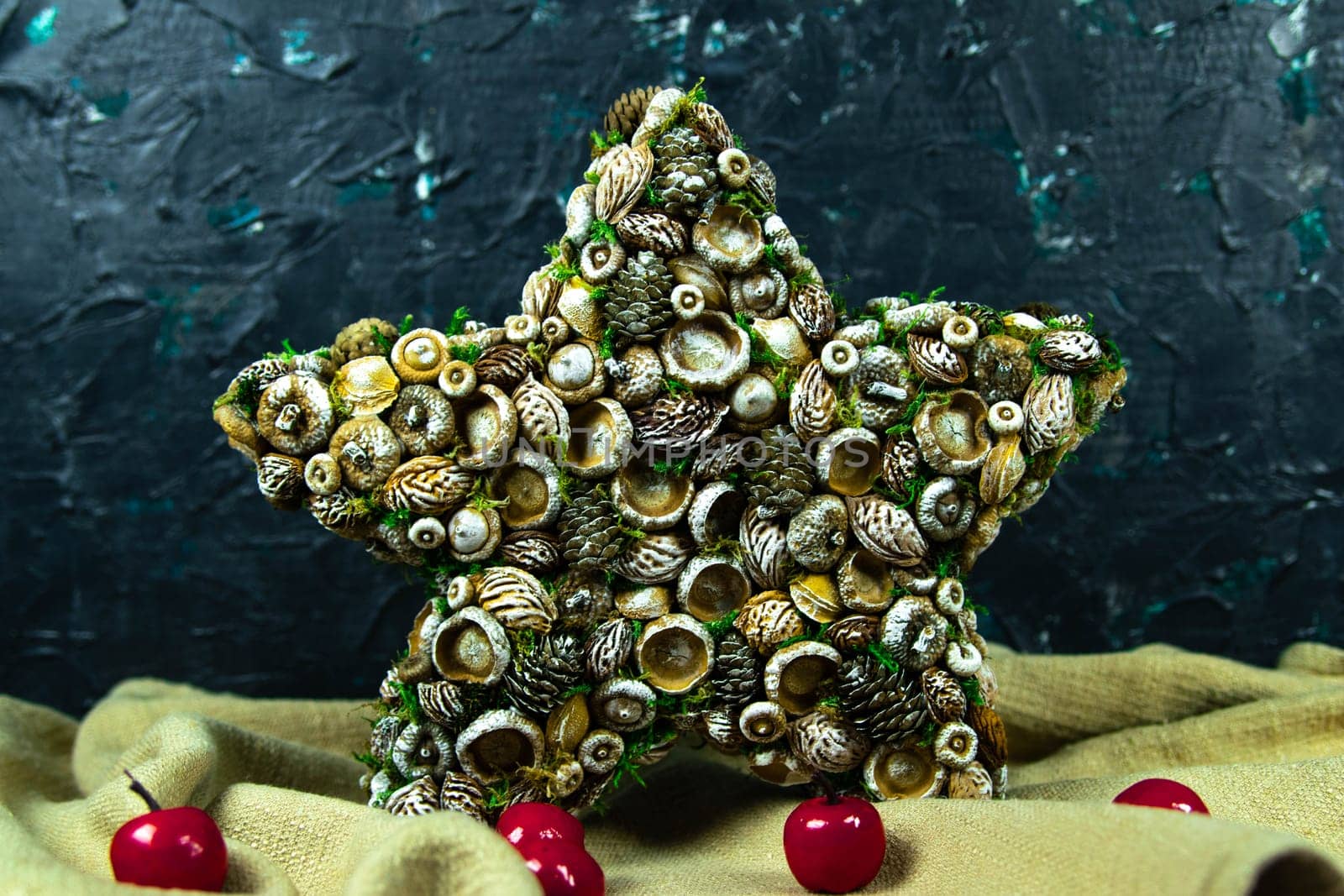 Handmade star decorated with cones and cranberries with christmas deer