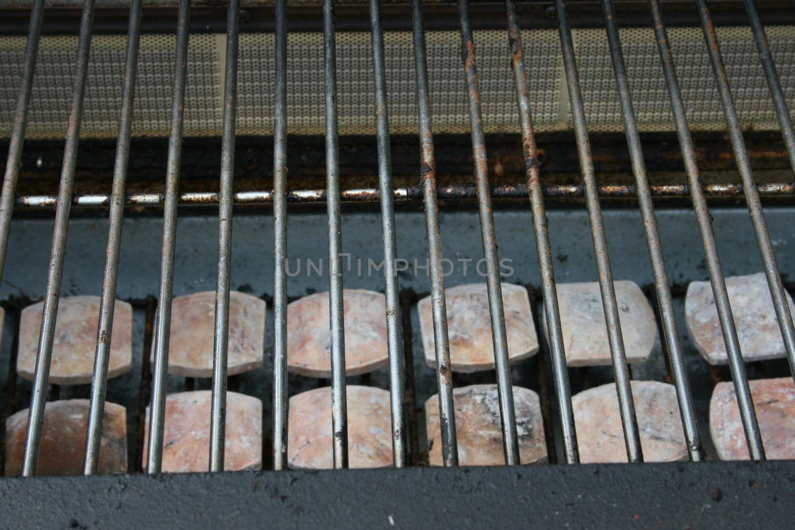 The grate of a gas grill with ceramic stones
