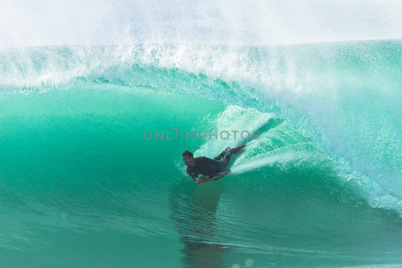 Surfing surfer  body boarding riding good size hollow powerful  ocean wave .