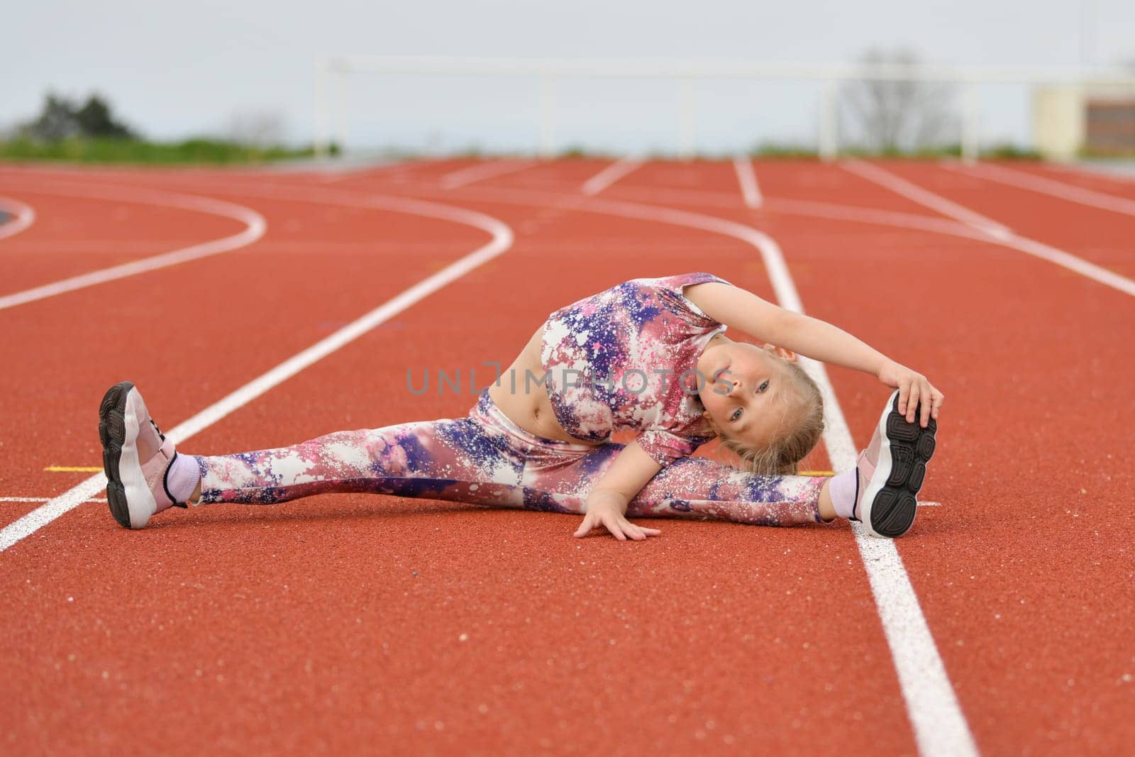 Girl in a pink legging doing splits at the stadium