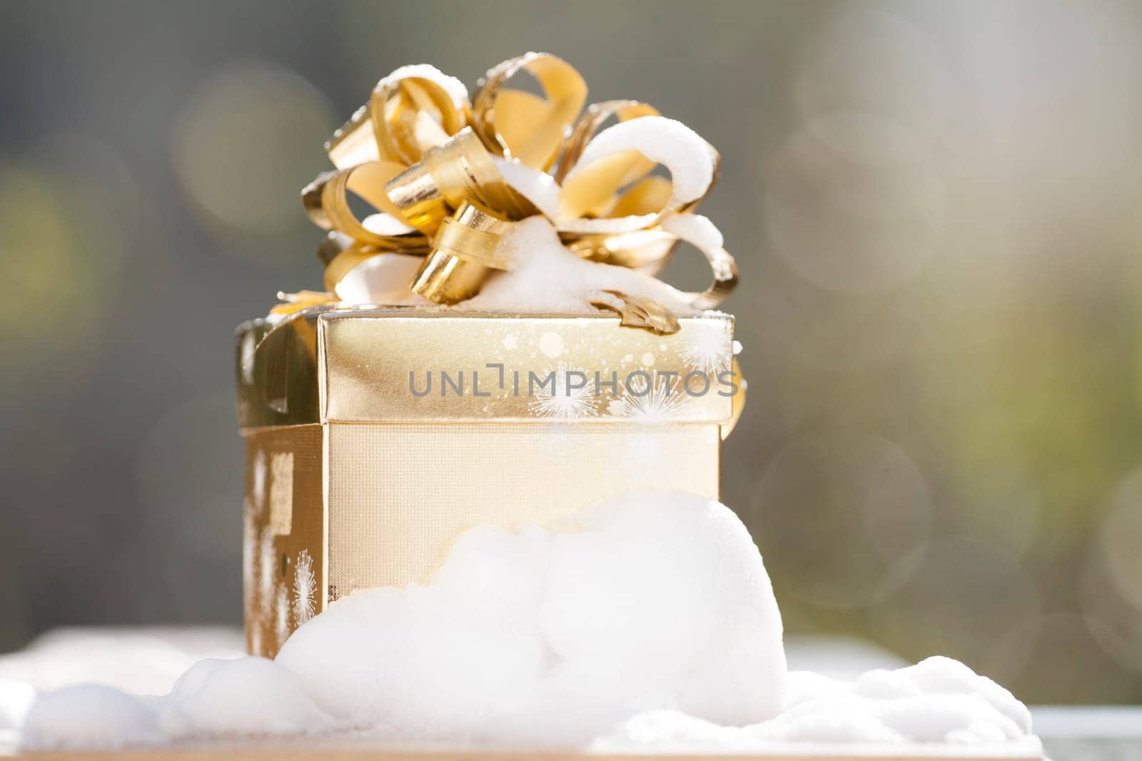 Golden Christmas background with present box on snow