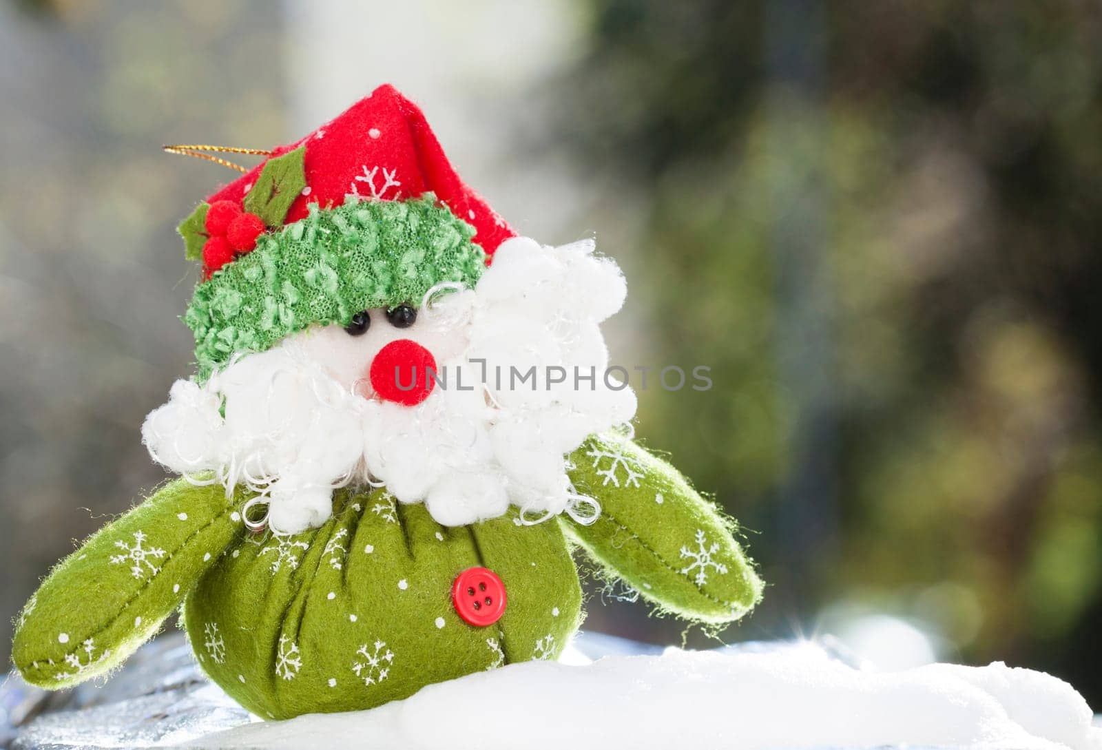 Christmas decoration with closeup on green Santa Claus figurine in the snow