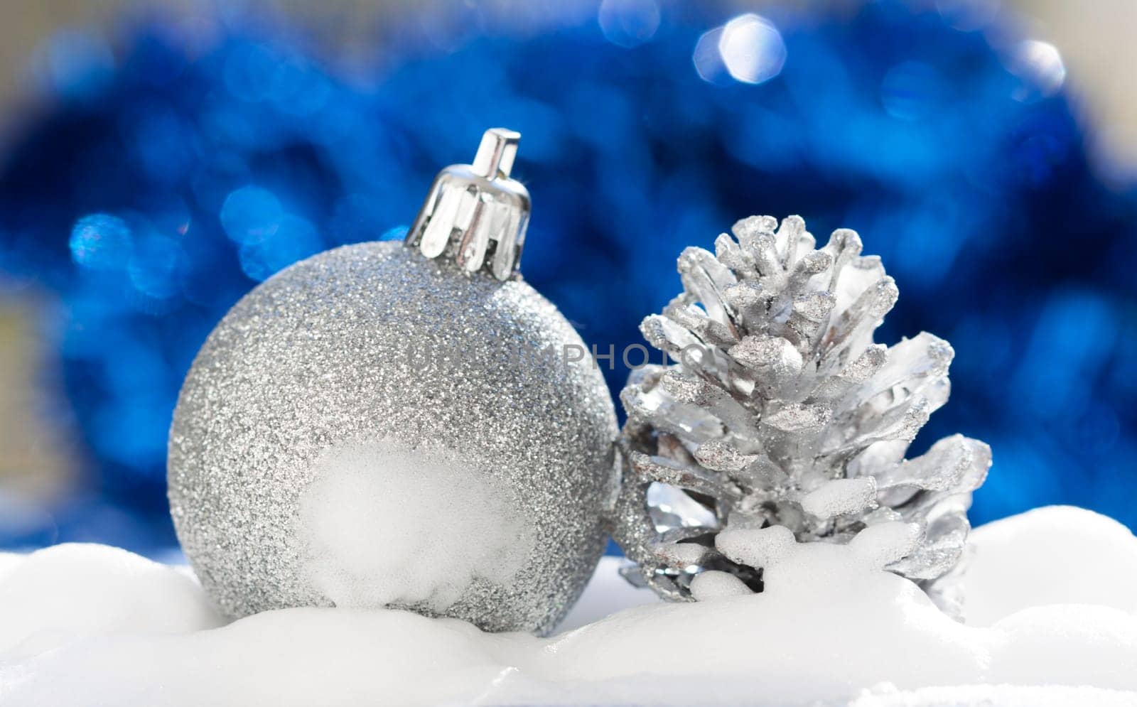 Silver christmas decoration with ball and cone on blue background