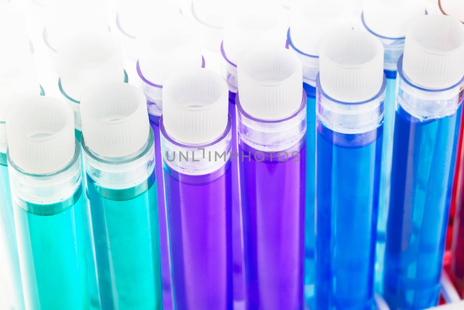 Colorful liquids, green, purple, blue, red and yellow, in test tubes with stoppers.