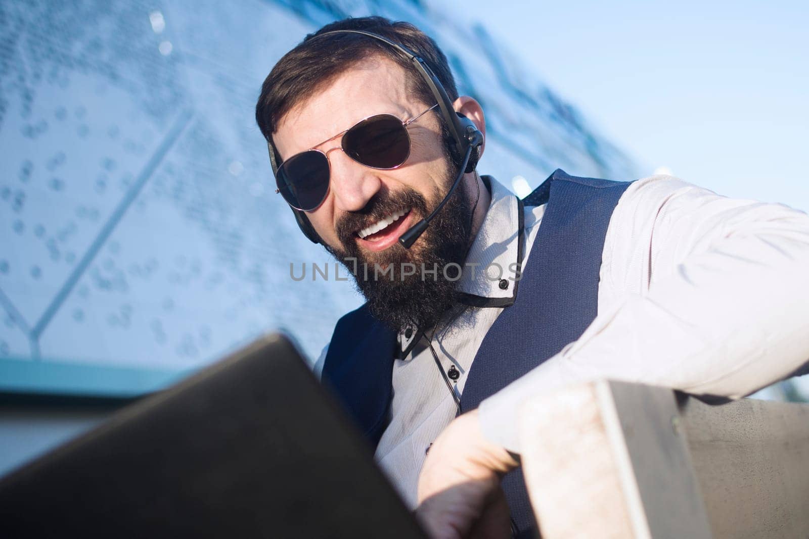 The virtual assistant or financial advisor with earphones and microphone is working online on laptop.
