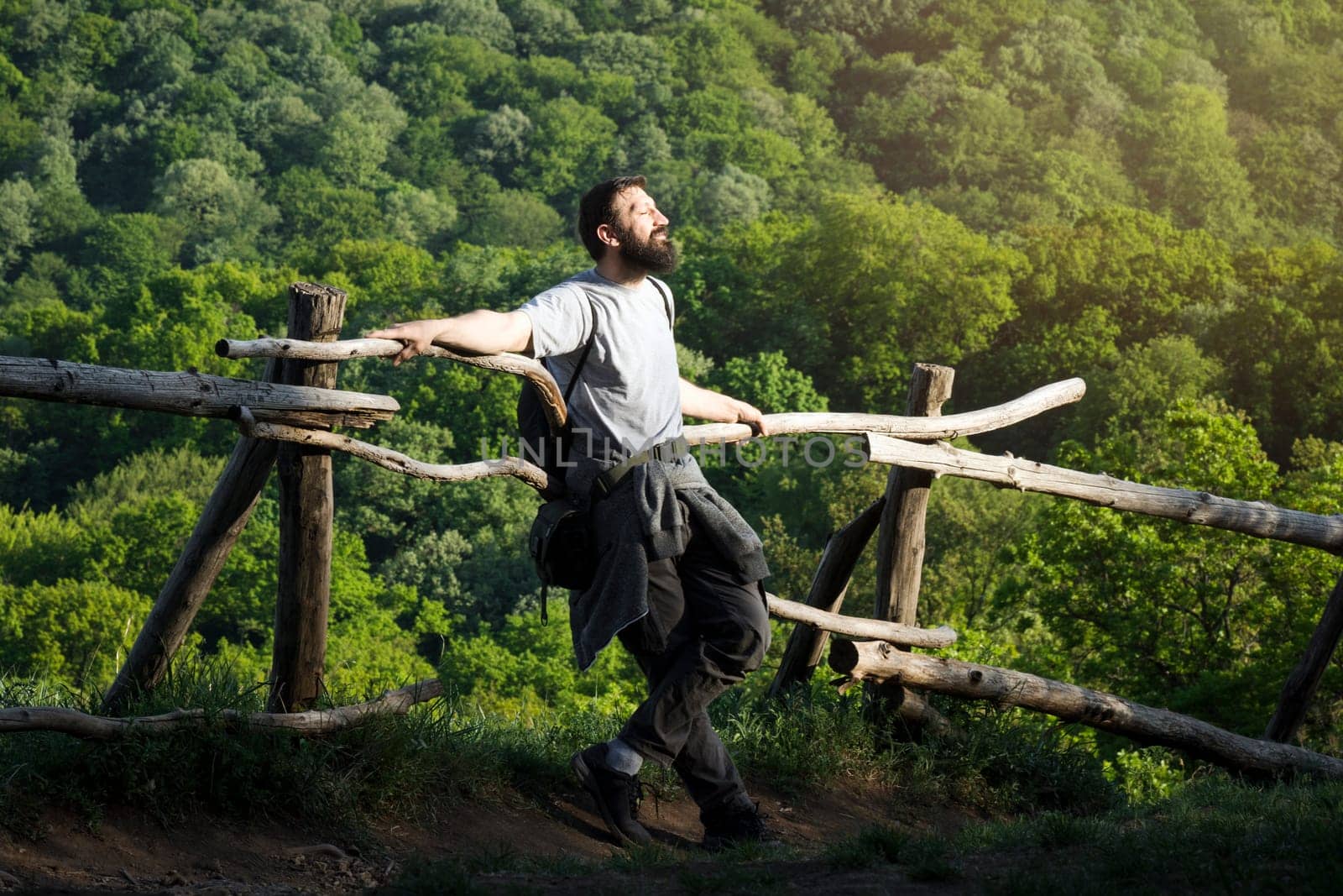 The bearded man is enjoying in nature on fresh air, sunlight and adventure on the trip.
