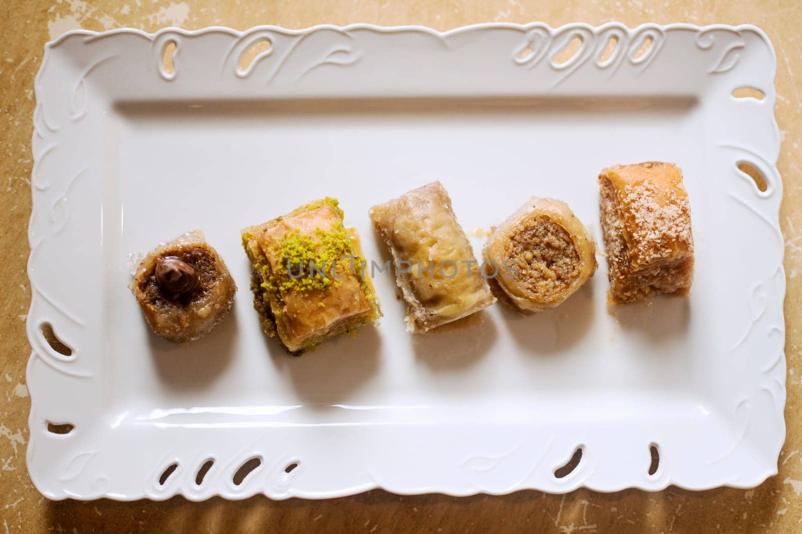 Five different taste of baklava, traditional Turkish dessert on white plate.
