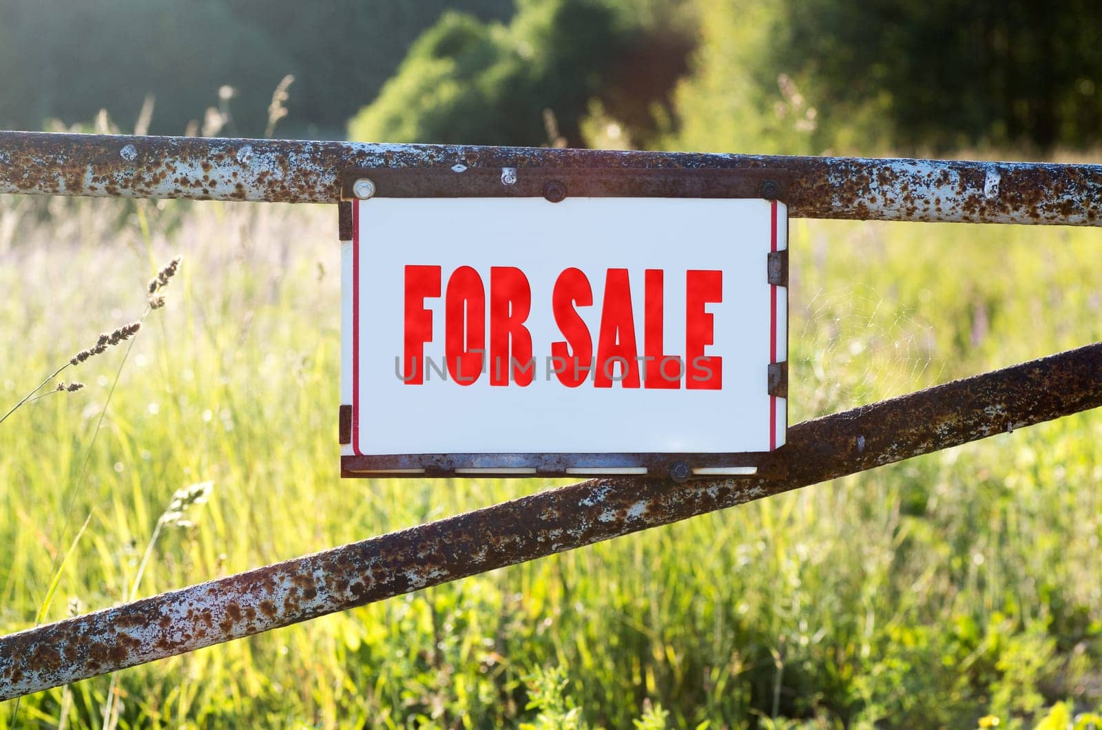 Sign For Sale on a metal gate on the dirt road