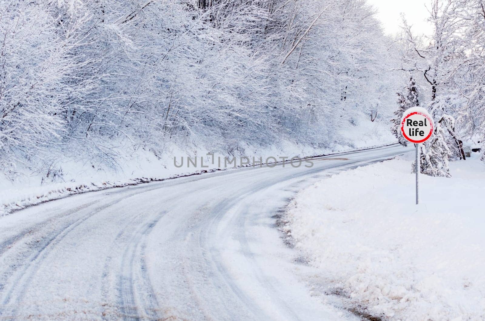 Snow tracks on a country road and road sing showing real life.