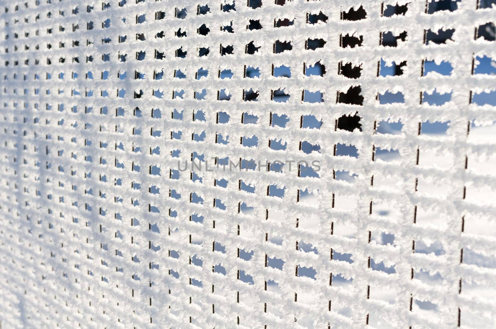 Detail of net, fence covered by snow and hoarfrost.
