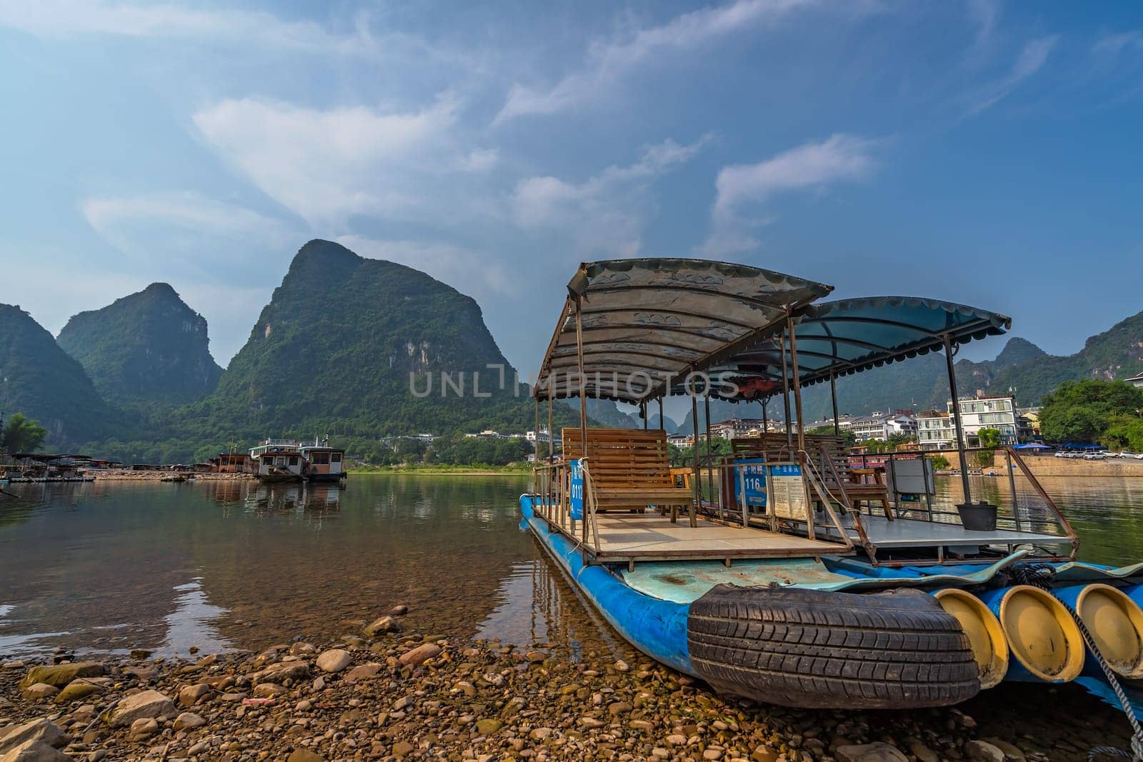 Yangshuo, China - August 2019 : Small tourist and fishermen boats on the Li river shore, the ferry crossing point in Yangshuo