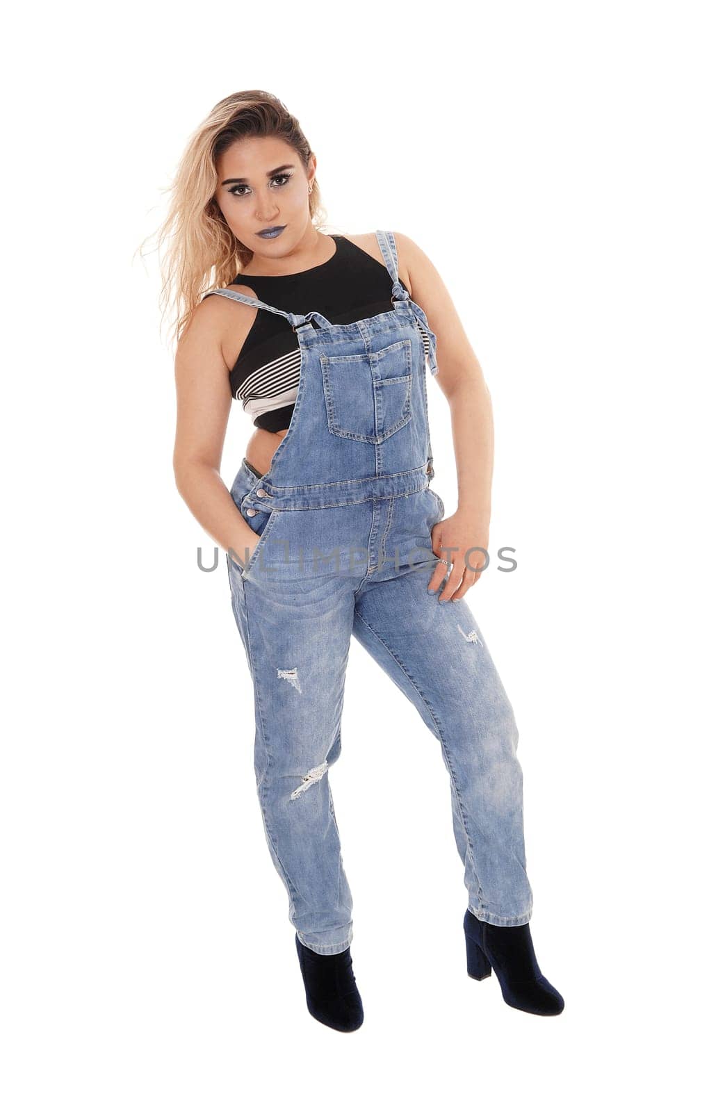 A gorgeous young woman standing in profile in working jeans and.with her hand in the pocket, isolated for white background.