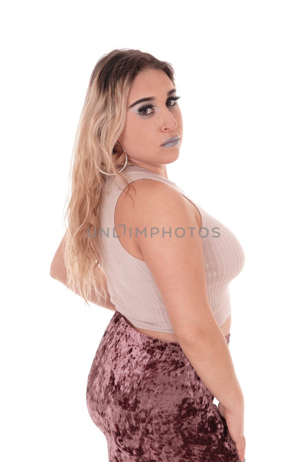 A young beautiful woman standing in profile, looking into the .camera from the waist up, isolated for white background.