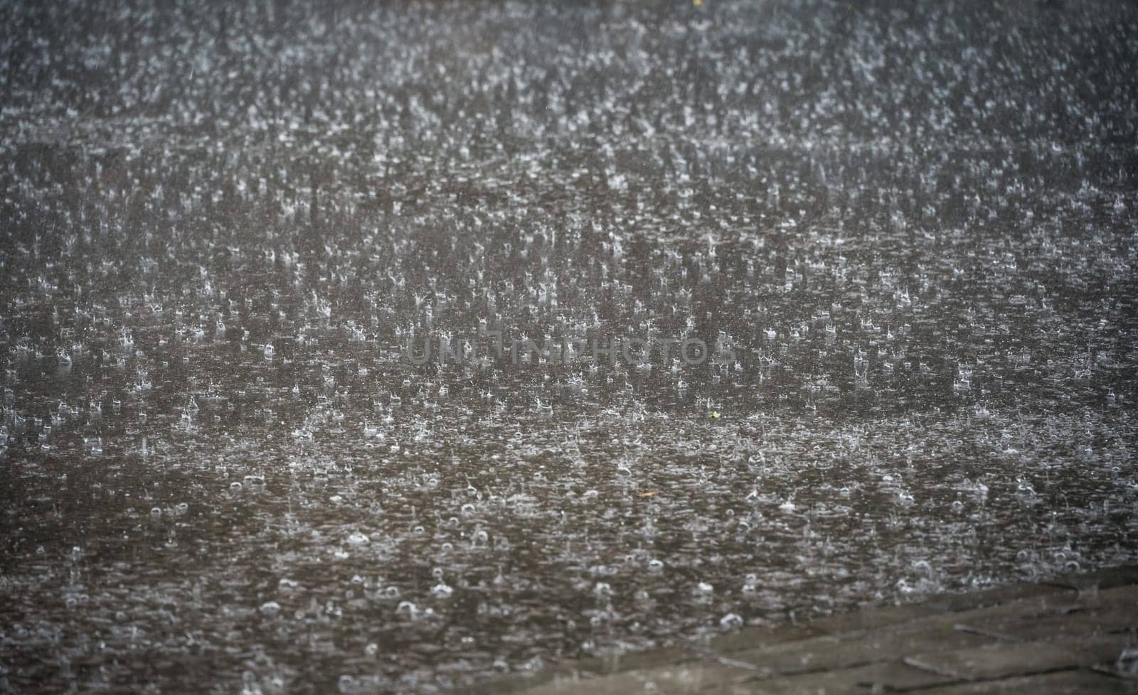 Heavy falling and splashing monsoon rain on the street background detail overlay