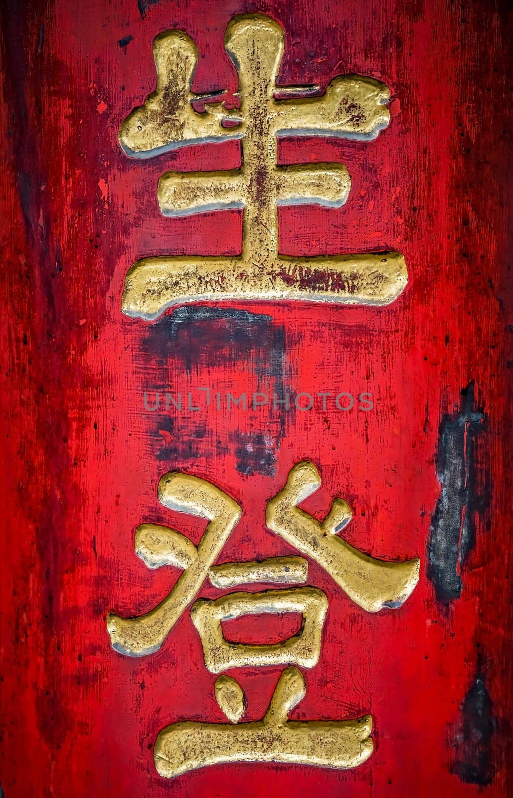 Golden chinese writing characters on a red wall background in the Wenshu Monastery, Chengdu, Sichuan Province, China