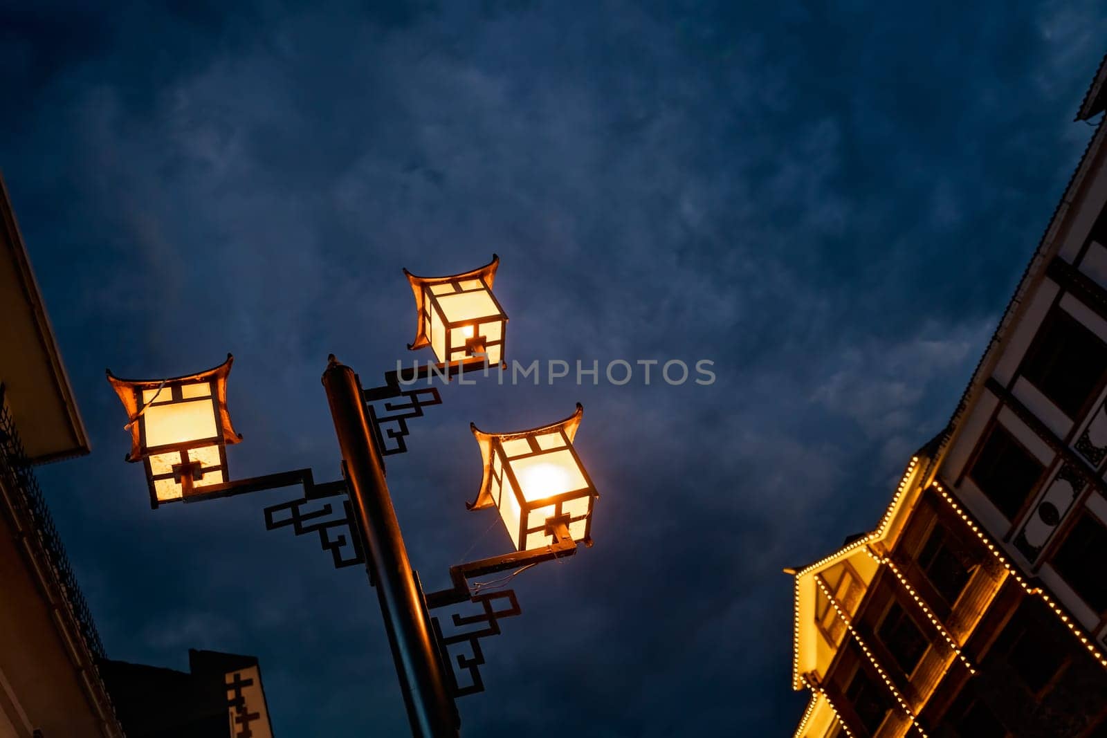 Brightly lit lamppost on the street in Wulingyuan after dusk at night, Hunan Province, China