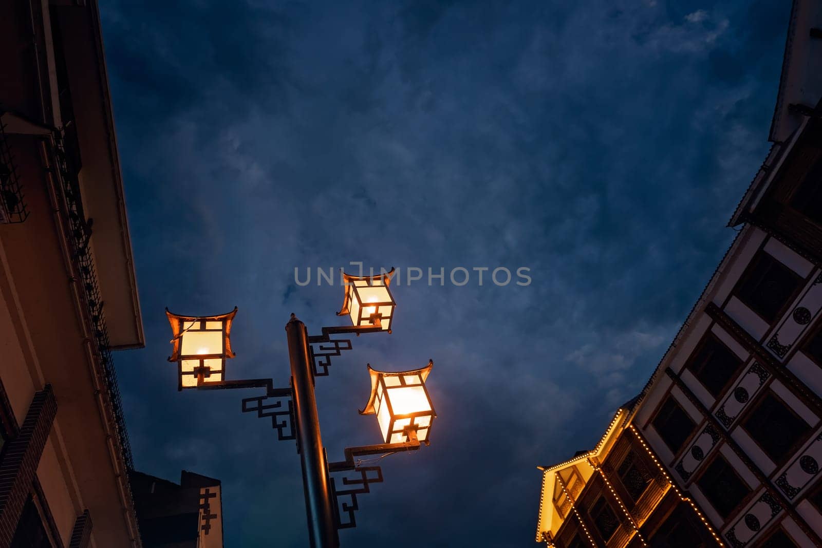 Brightly lit lamppost on the street in Wulingyuan after dusk at night, Hunan Province, China