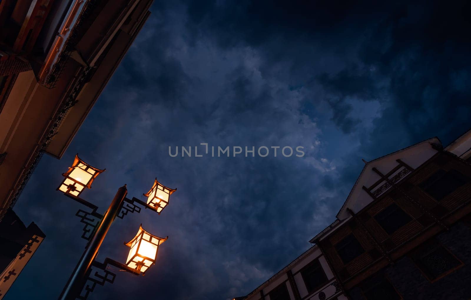 Brightly lit lamppost on the street in Wulingyuan after dusk at night, Hunan Province, China
