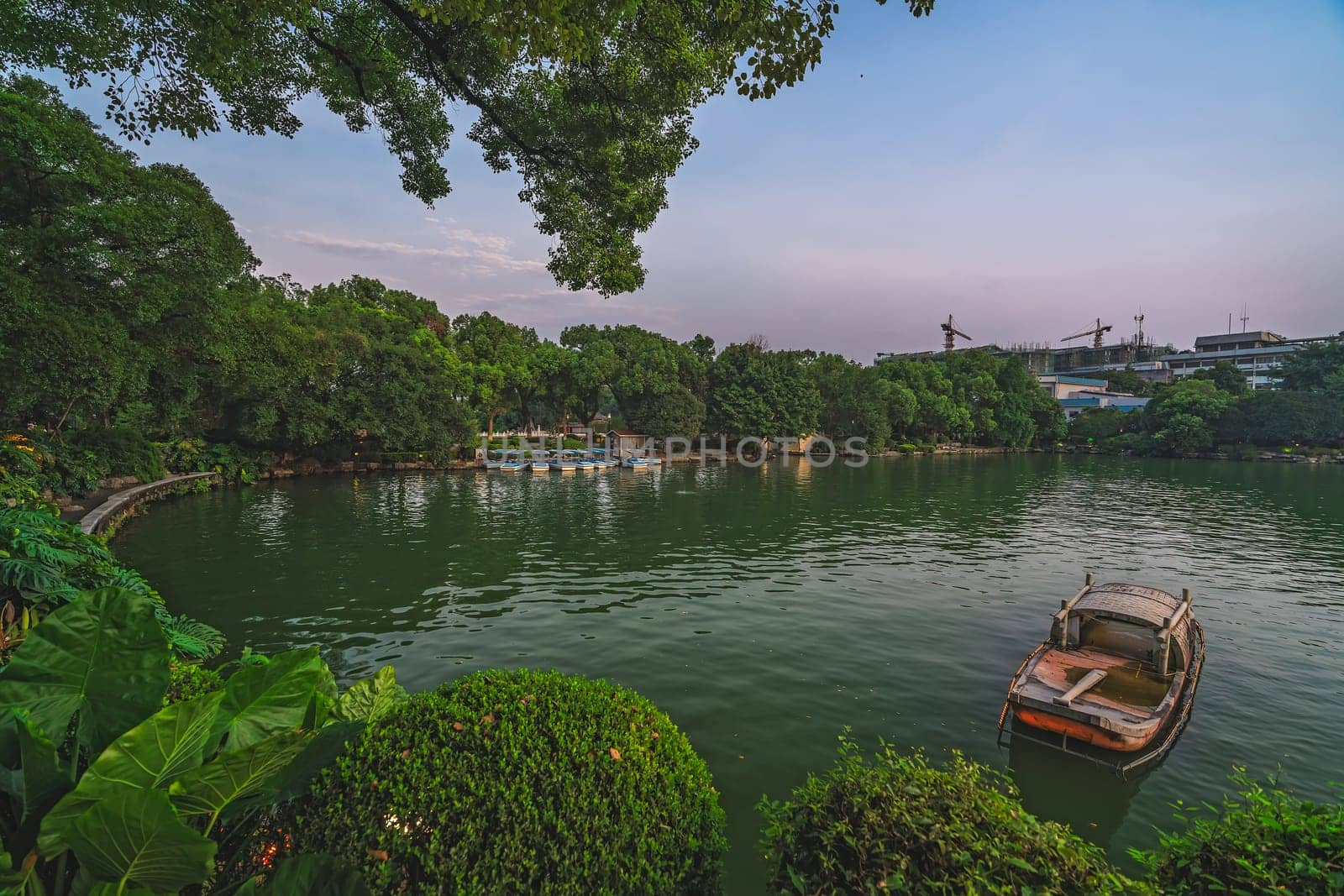 Small wooden boat moored on the shore of Shanhu or Shan Lake in Guilin town, Guangxi Province, China