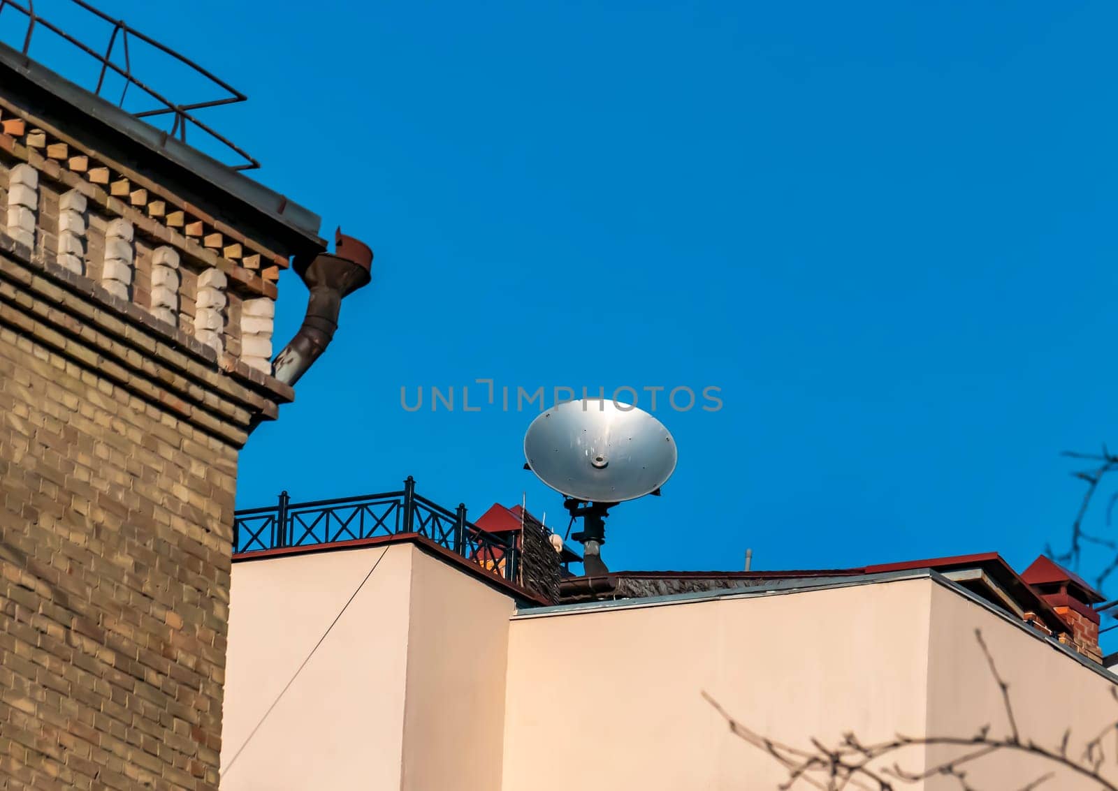 Satellite dish on the roof of the building against the blue sky. Technology. Place for text. Background image.