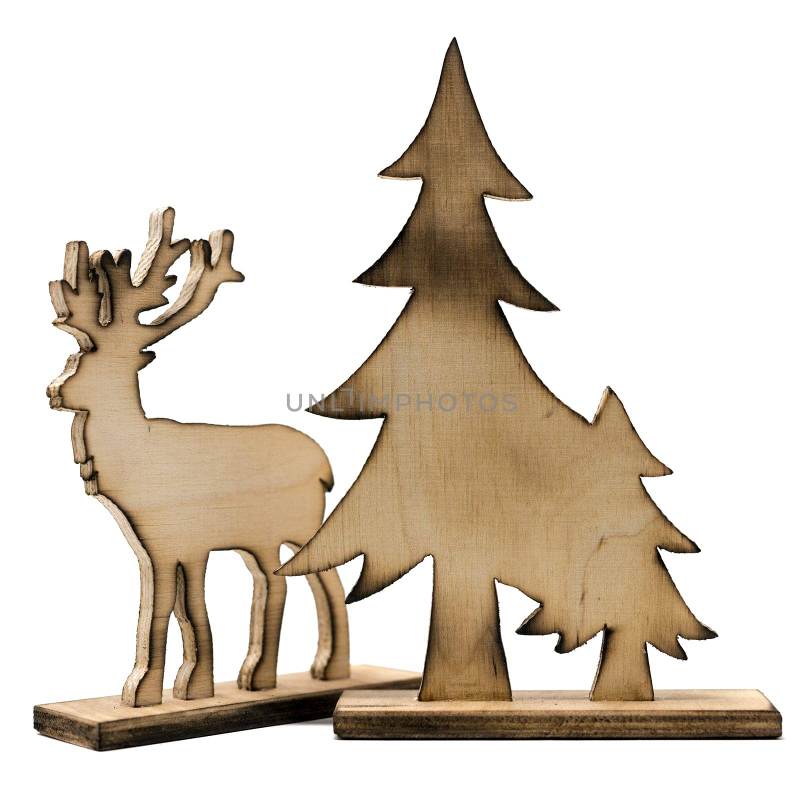 Cut out deer figure made of wood with dark edges and wooden fir trees isolated on white