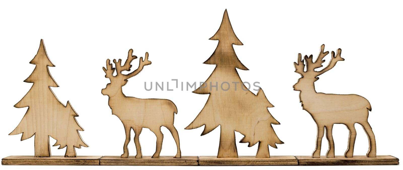 Cut out deer figure made of wood with dark edges and wooden fir trees isolated on white