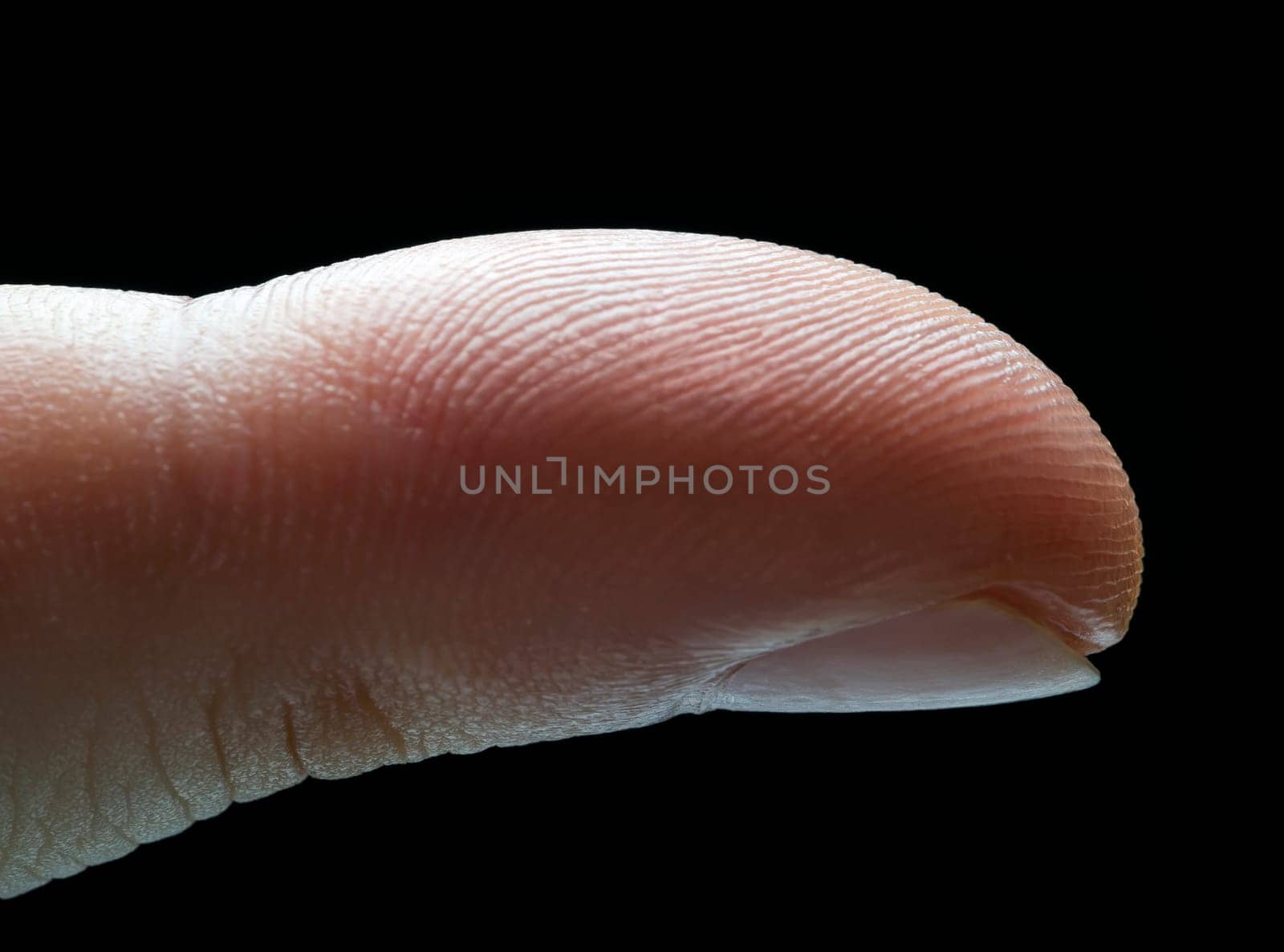 Photo of side index finger with illumination showing fingerprint over black background.