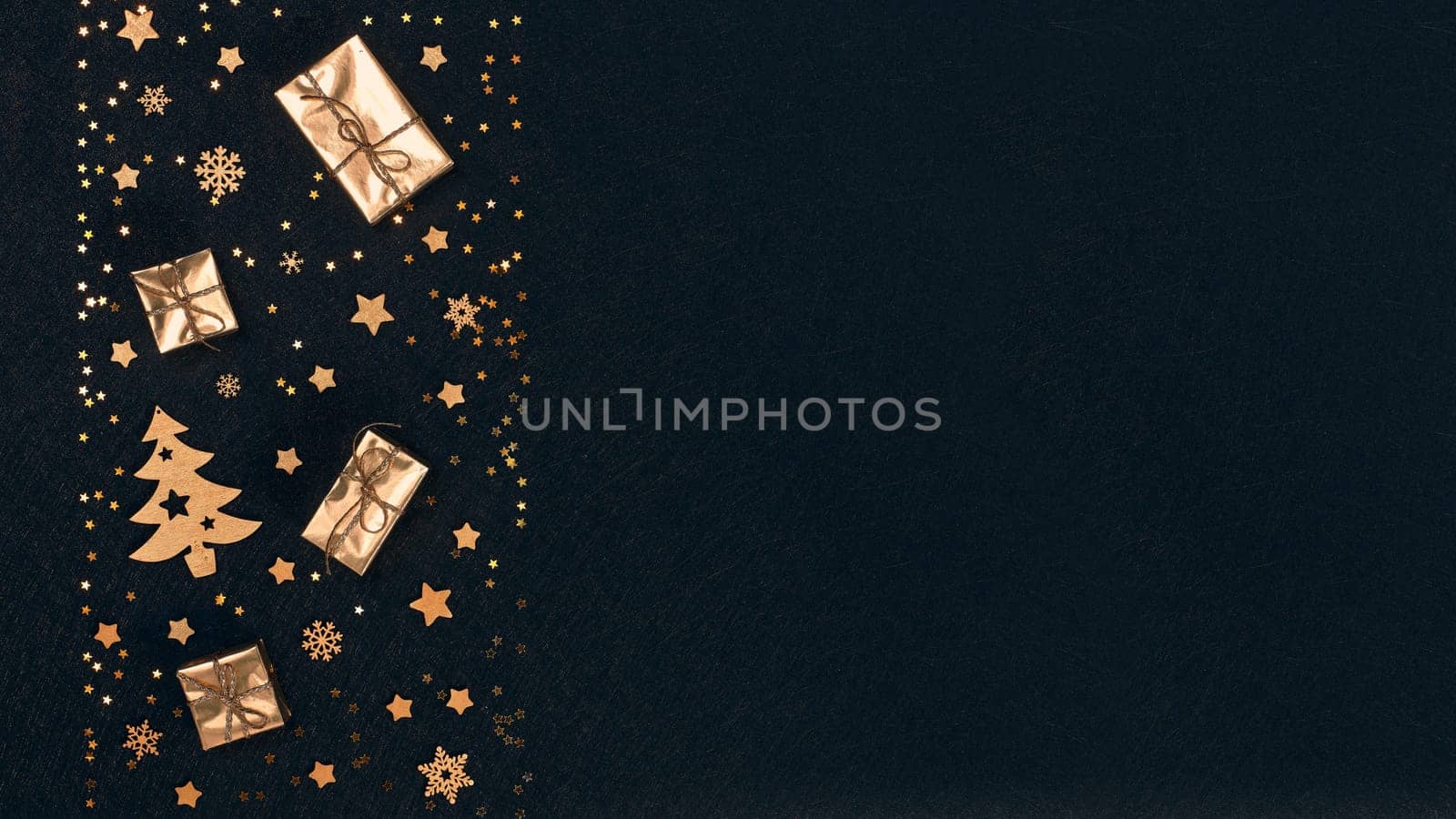Festive composition with golden Christmas decorations and gold gift boxes on black textured background. Top view with copy space, Design element for greeting card, invitation, advertising, winter sale