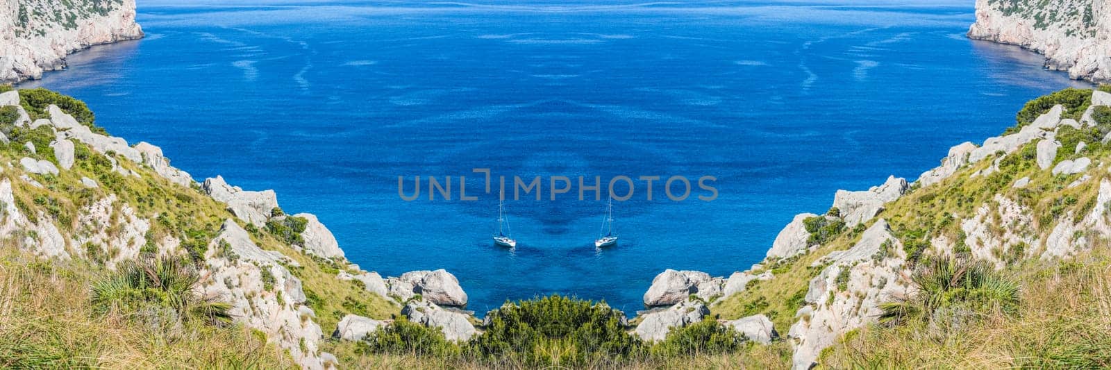 Panorama, secluded cove in picturesque Seascape with 2 sailboats on the island of Mallorca, Spain.