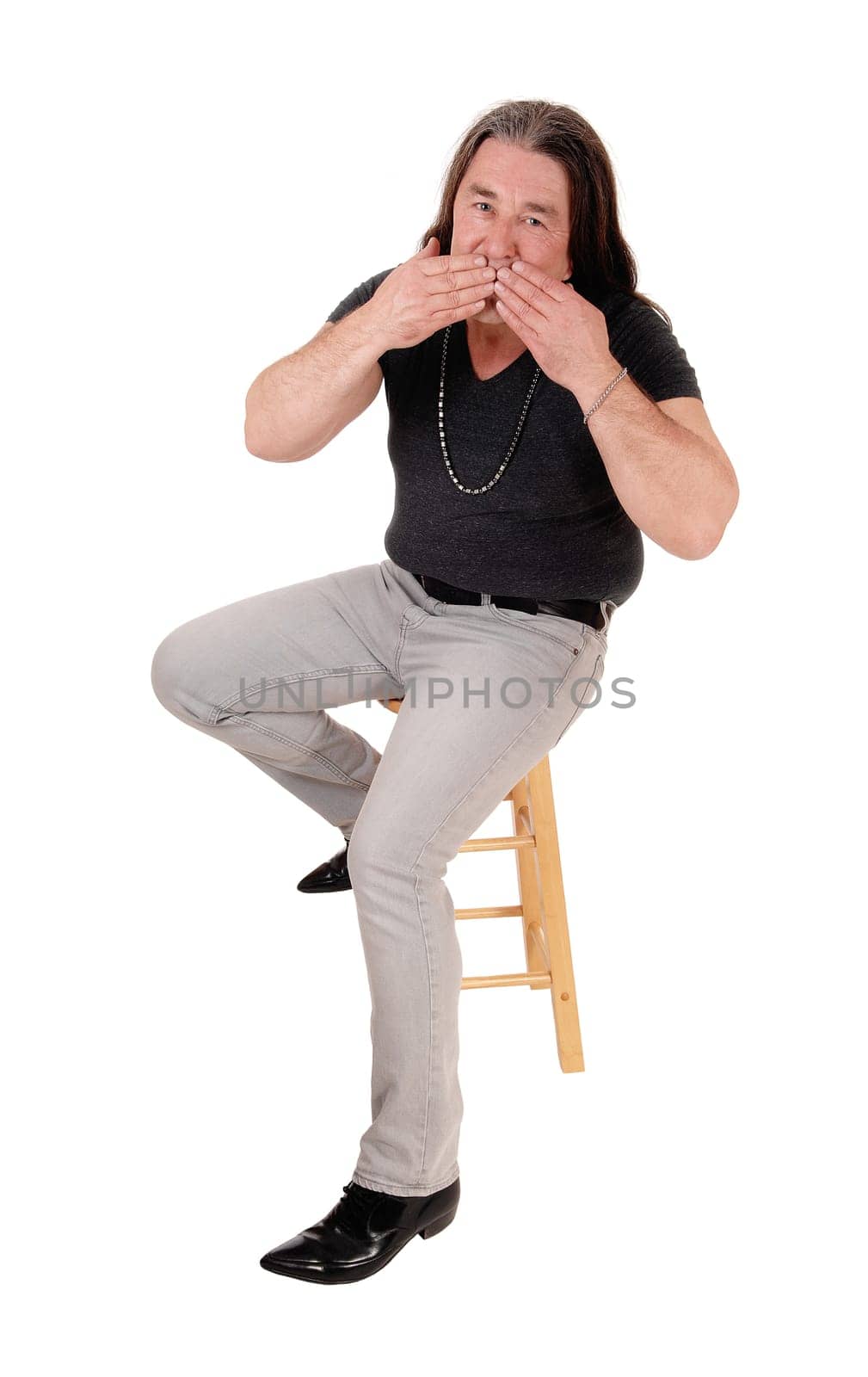 A image of a middle age indigenous man sitting on a chair.and blowing a kiss, isolated for white background.
