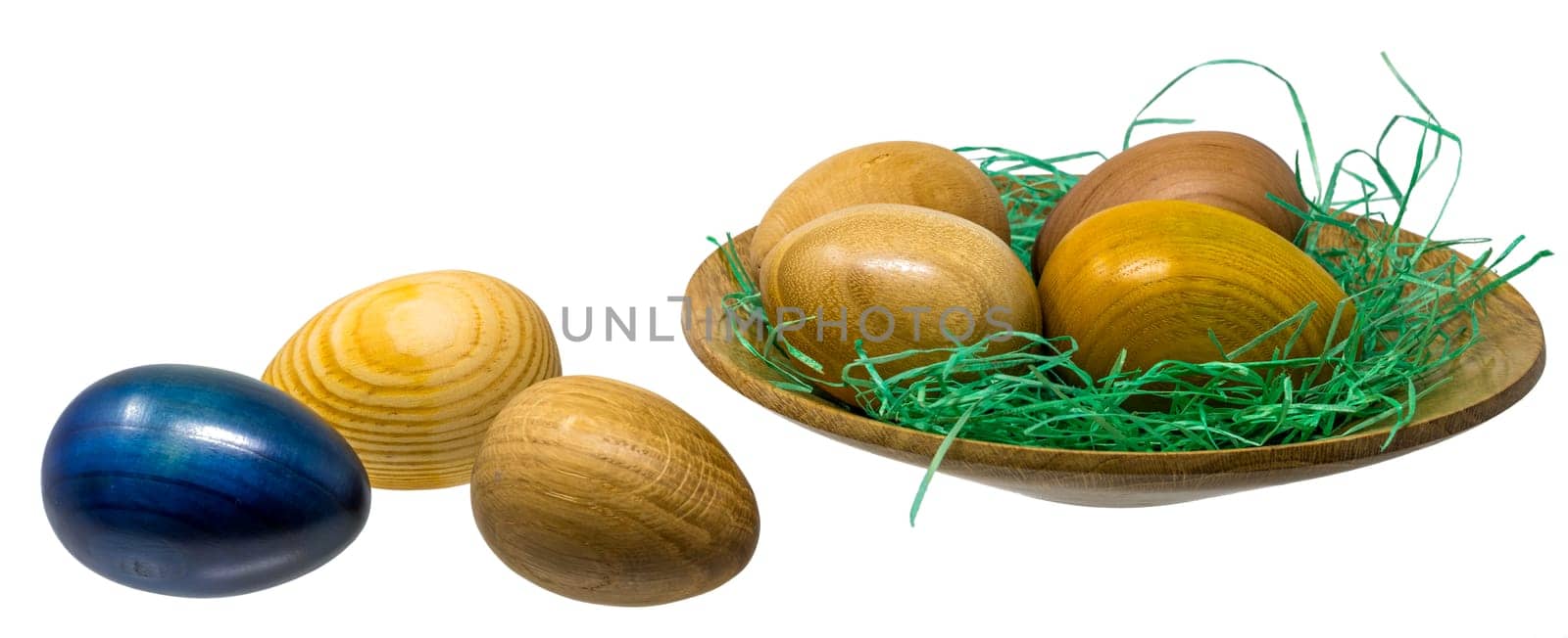 Hand-turned wooden eggs in a smal wooden bowl isolated on white