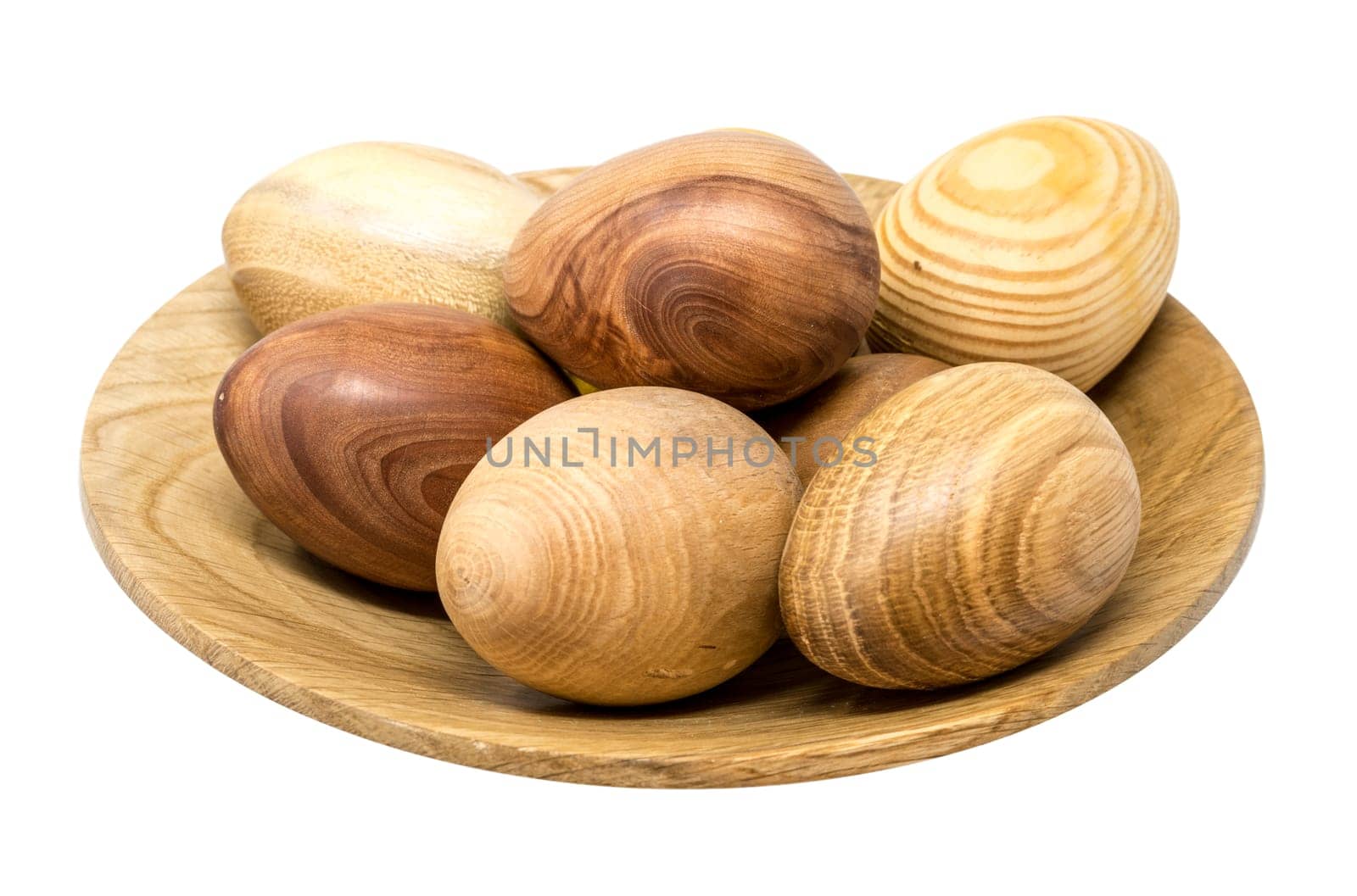 Hand-turned wooden eggs in a smal wooden bowl isolated on white