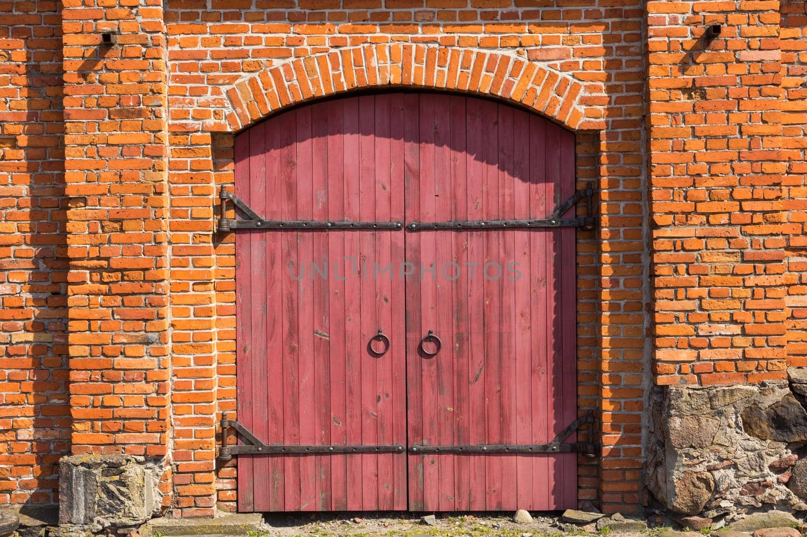 Red wooden door in red brick wall