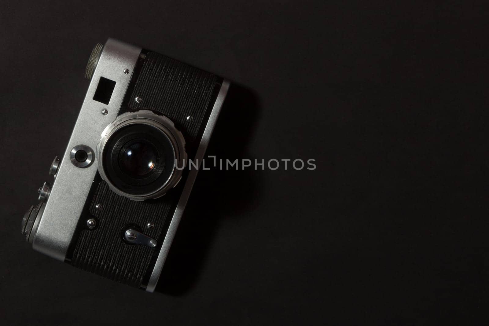 Retro film photo camera on black background