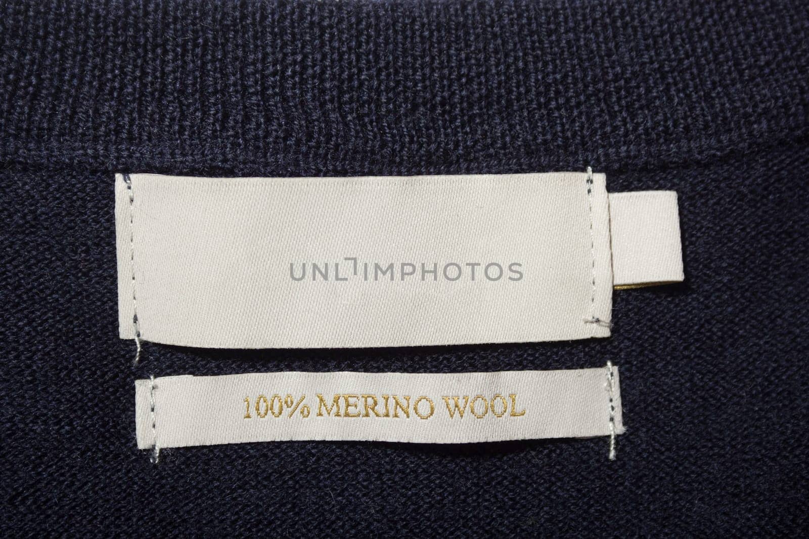 100 merino wool label on the sweater dark blue wool fabric.