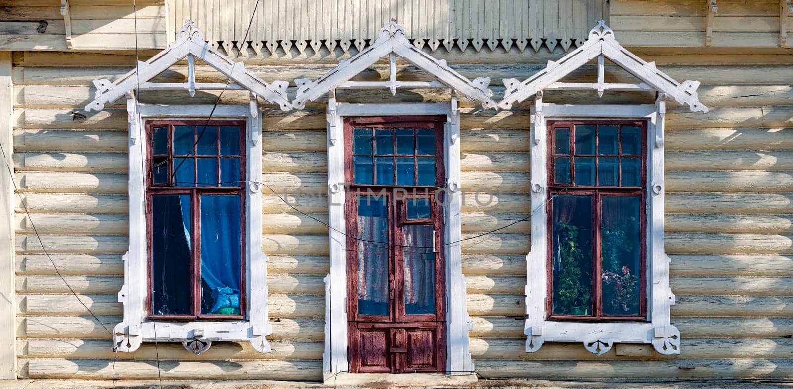 Old wood log background with cracks and lines. Windows on wall of house.