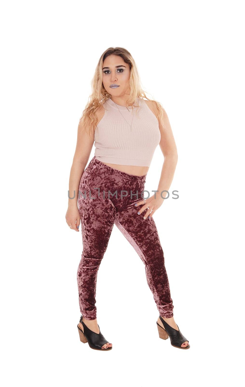 A beautiful young blond woman standing from the front, looking into .the camera, isolated for white background.
