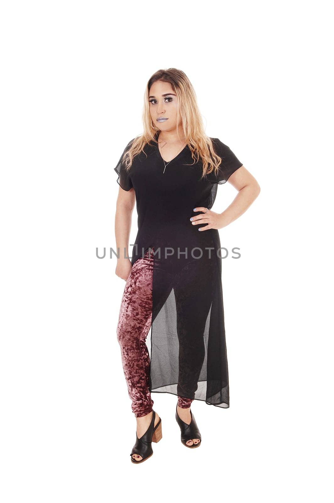 A lovely young woman standing from the front in a black dress with . colorful tights under, isolated for white background.