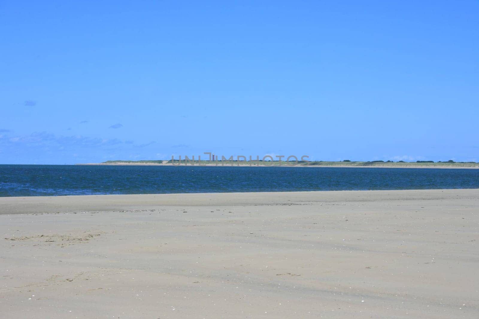 Sandy beach with sea and blue sky background