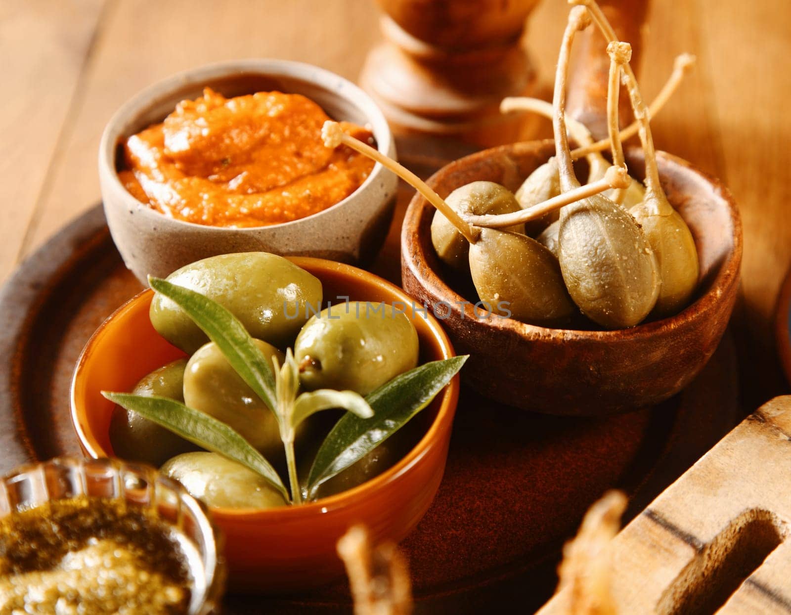 Bowls of olives with savory sauces displayed on a buffet table as appetizers at a catered event