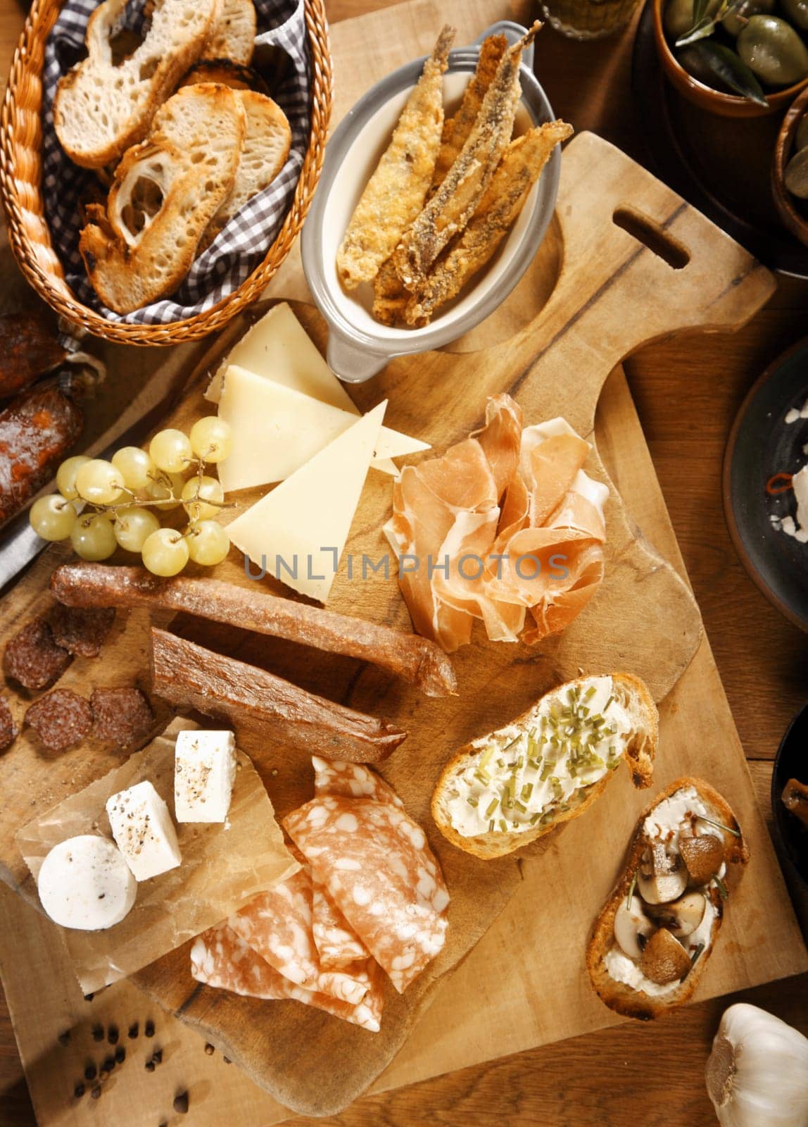 Close up Assorted Appetizing Tapas on Wooden Board, Emphasizing Ham, Cheese and Bread.