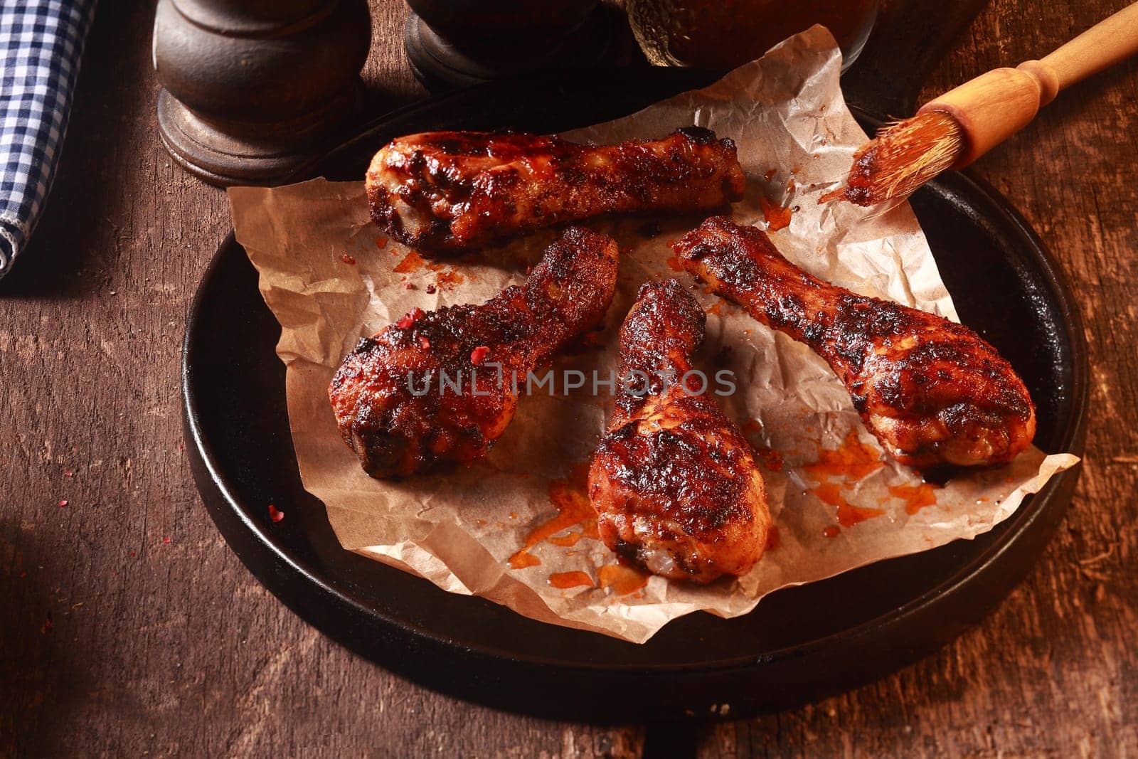 Four Saucy Barbecued Chicken Drumsticks on Cast Iron Pan