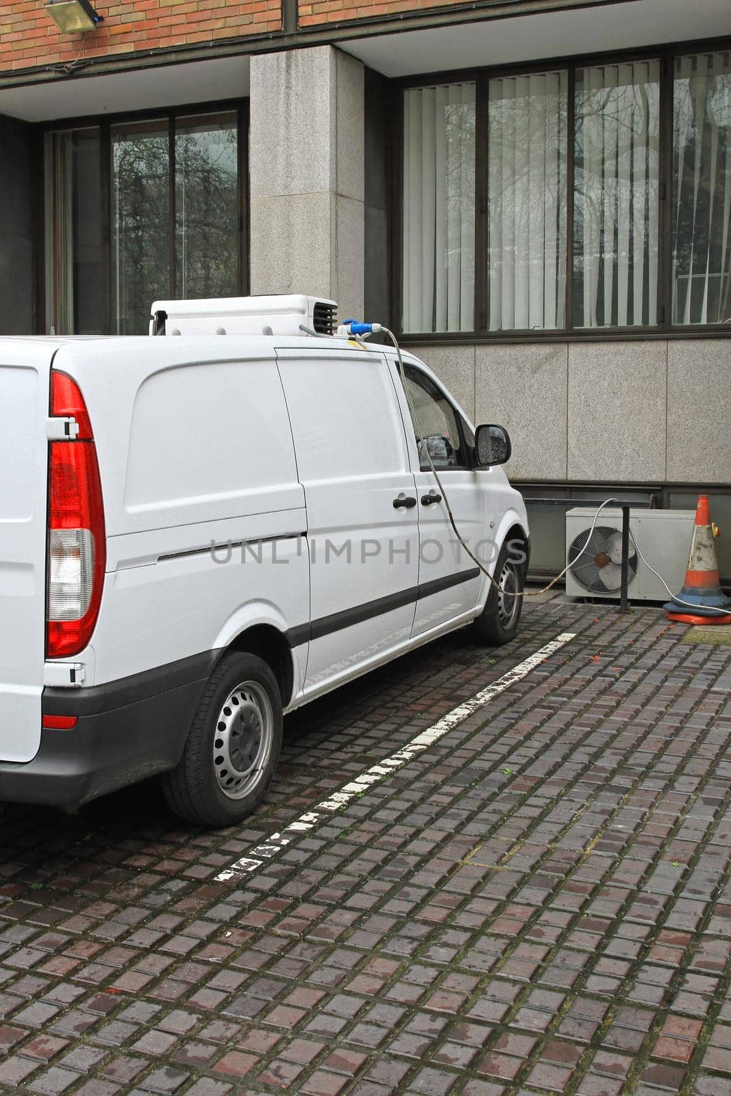 Electric refrigeration van charging on parking spot