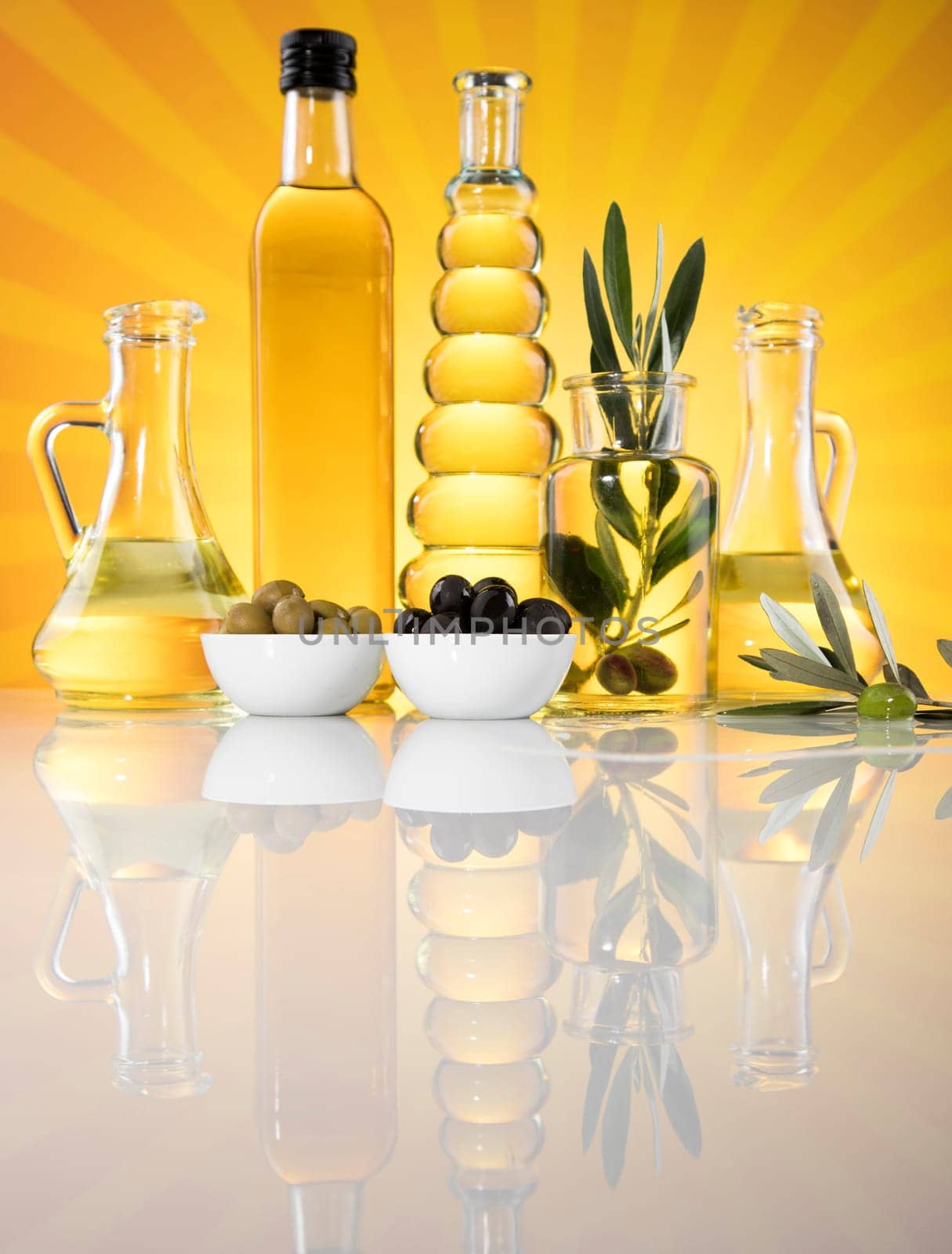 Bottles with organic cooking olive oil and olive branch