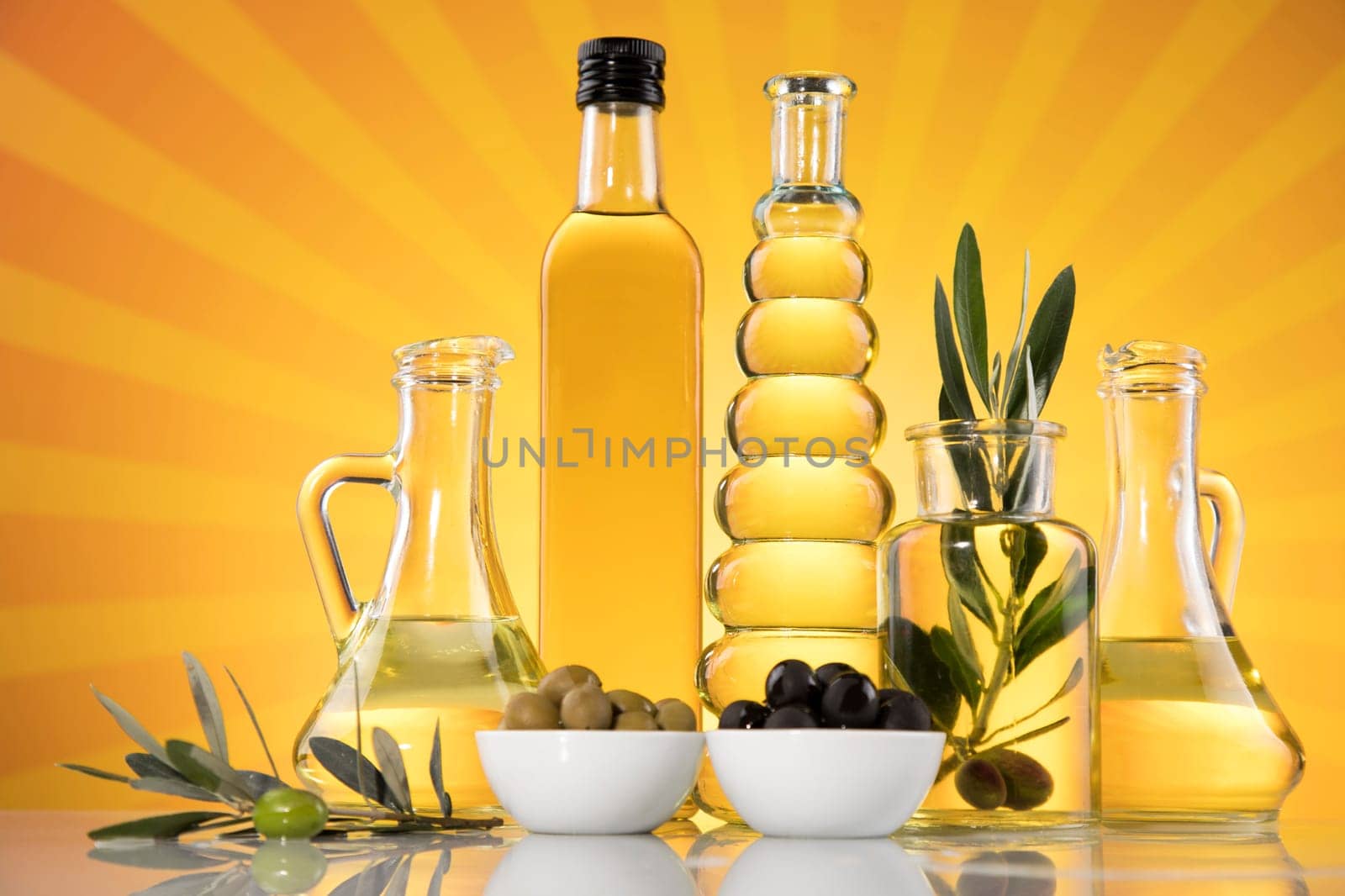 Bottles with organic cooking olive oil and olive branch